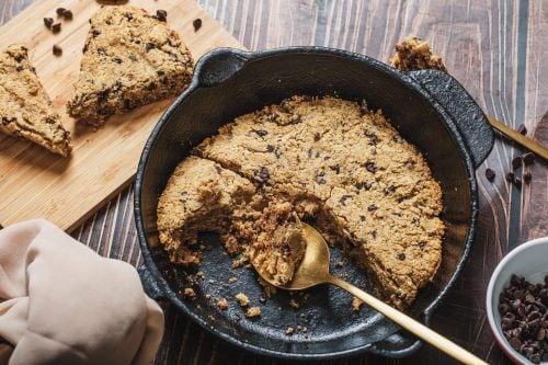 Skillet cookie with spoon removing a slice