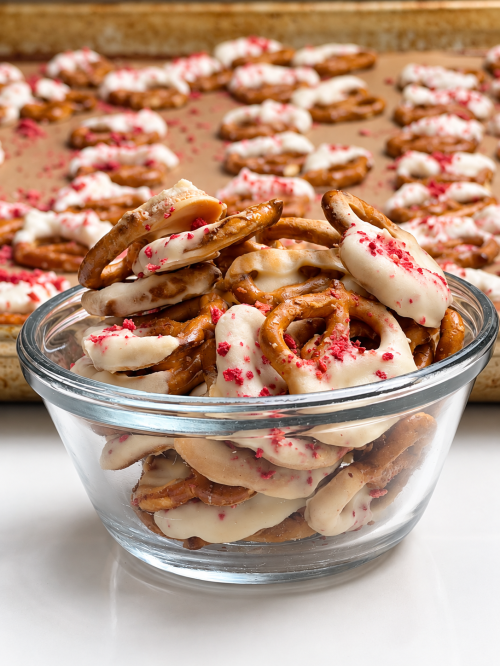 Bowl of strawberry yogurt-covered protein pretzels topped with crushed freeze-dried strawberries