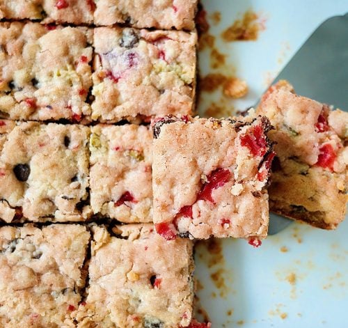 Freshly baked Swiss Treat cookie bars in a pan with a golden top and visible mix-ins.
